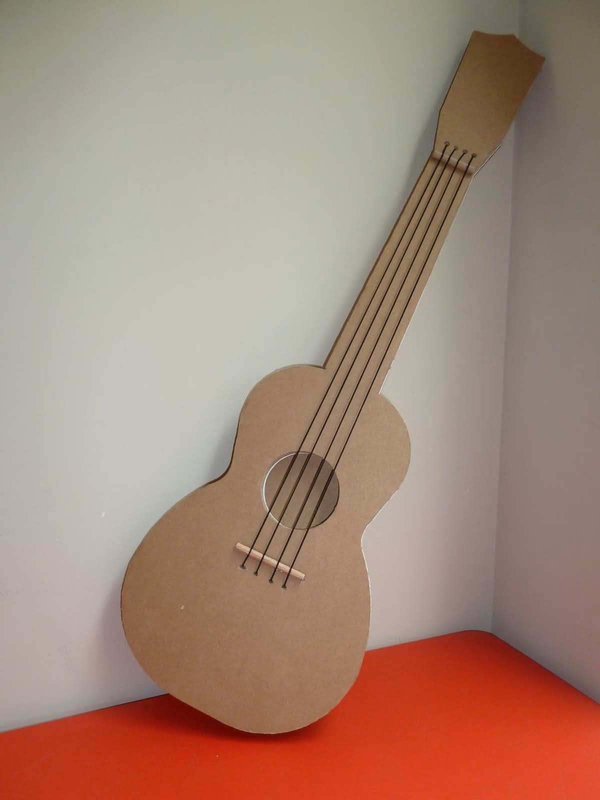 ¿Cómo se coloca el rollo de cartón en la guitarra?